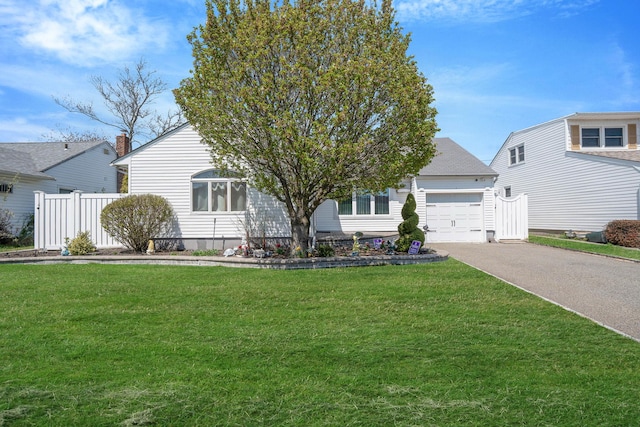 view of front of property with fence, aphalt driveway, a front lawn, and an attached garage