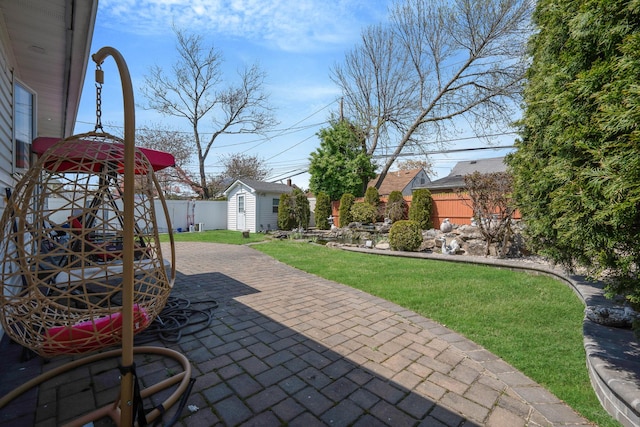 view of patio with an outdoor structure, a fenced backyard, and a storage shed