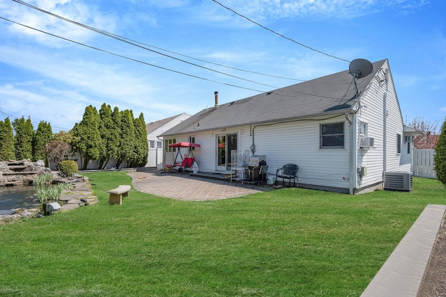 rear view of house featuring roof with shingles, a yard, and a patio