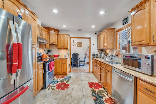 kitchen featuring recessed lighting, a sink, stainless steel appliances, under cabinet range hood, and light stone counters