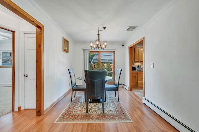 dining room featuring light wood-style flooring, a chandelier, visible vents, baseboard heating, and ornamental molding