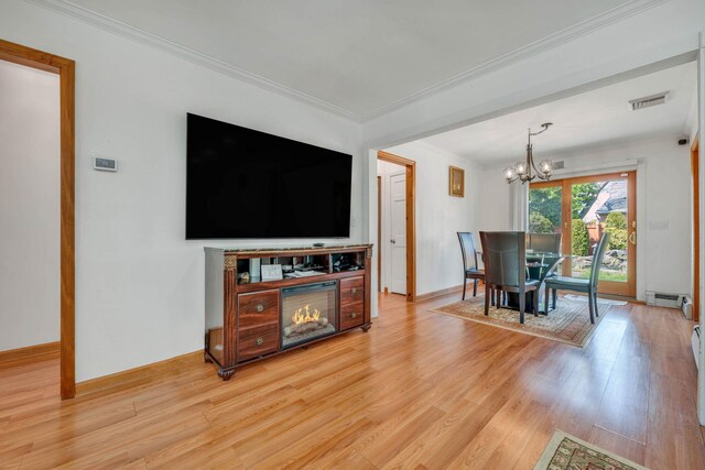 dining room with a chandelier, a baseboard heating unit, light wood-style floors, ornamental molding, and visible vents