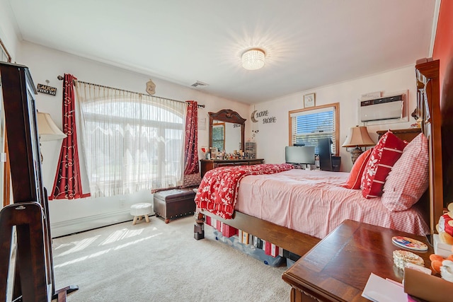 carpeted bedroom featuring visible vents, a baseboard heating unit, and multiple windows