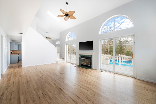 280 Shinnecock Hills Rd, Southampton, NY 11968 - unfurnished living room featuring a premium fireplace, a ceiling fan, high vaulted ceiling, and light wood-style floors
