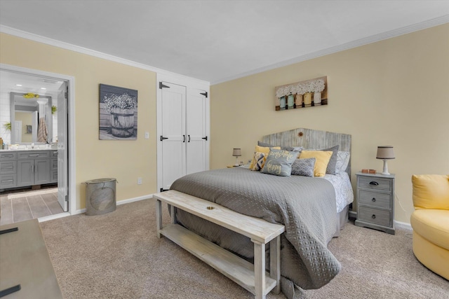 bedroom featuring crown molding, baseboards, light colored carpet, and connected bathroom