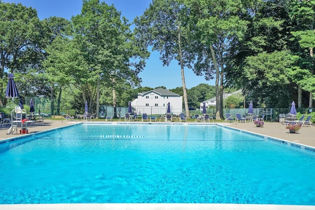 community pool with fence and a patio area