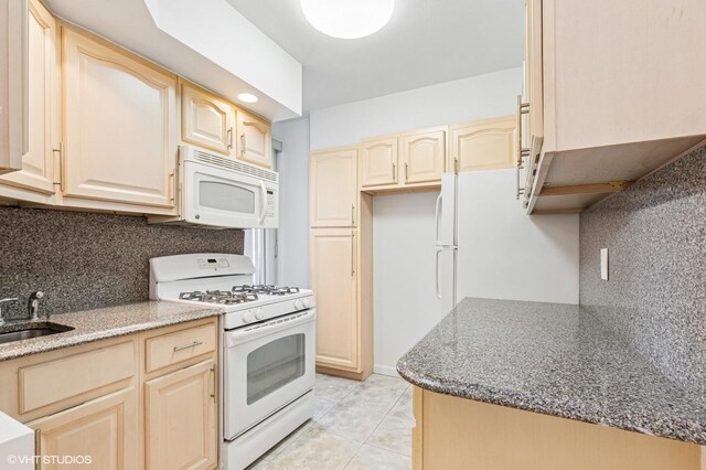 kitchen with white appliances, tasteful backsplash, light brown cabinetry, and light tile patterned floors