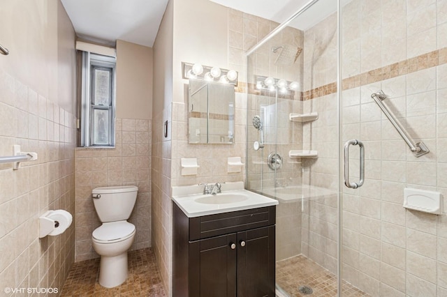 bathroom featuring a stall shower, tile walls, toilet, vanity, and tile patterned flooring