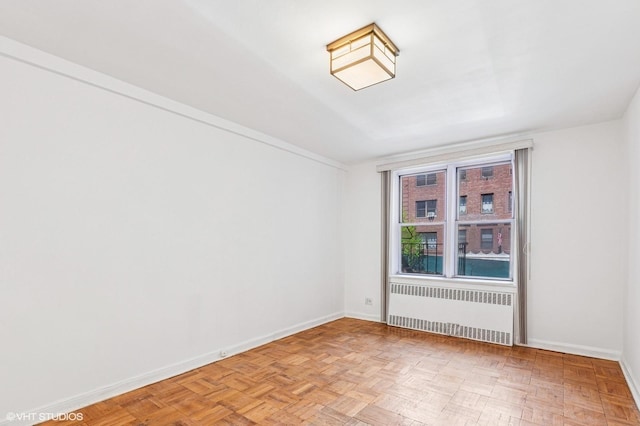 spare room featuring radiator heating unit and baseboards