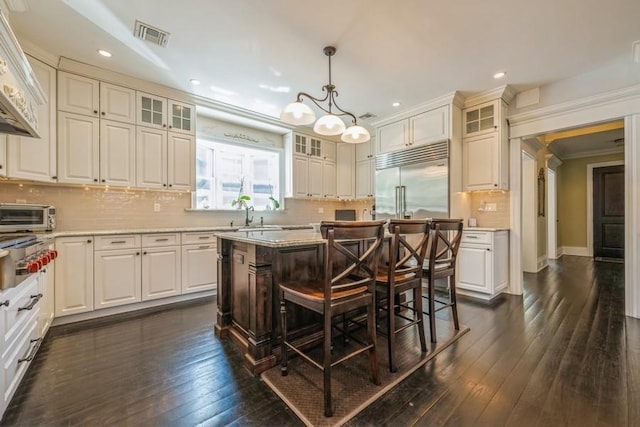 187 Lakeview Ave, Rockville Centre, NY 11570 - kitchen with built in fridge, recessed lighting, a kitchen island, backsplash, and dark wood finished floors