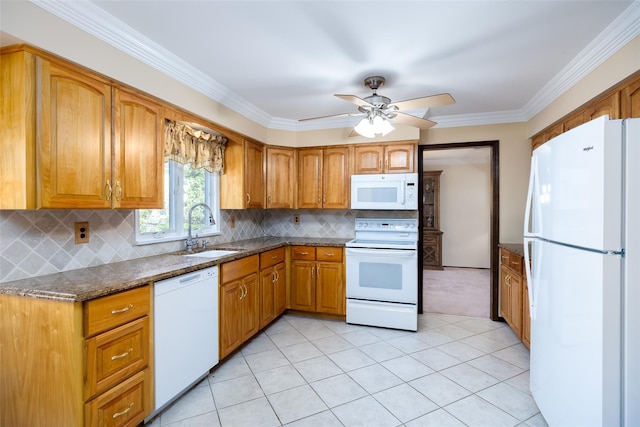 kitchen featuring dark stone countertops, white appliances, brown cabinetry, light carpet, and a sink