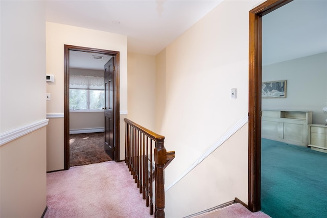 hall featuring an upstairs landing, carpet flooring, and baseboard heating