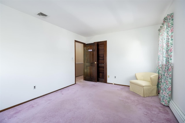 unfurnished room with baseboard heating, visible vents, carpet, and baseboards