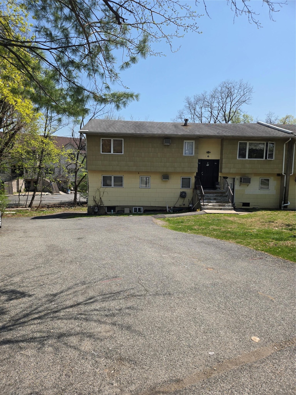 bi-level home featuring roof with shingles