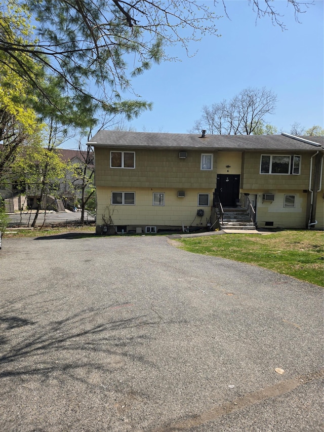 bi-level home featuring roof with shingles