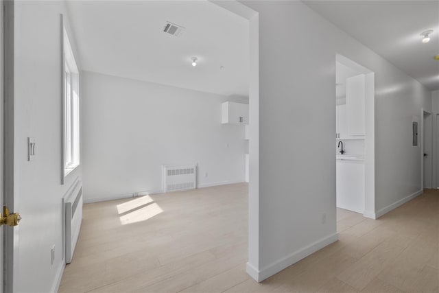 interior space featuring light wood-style floors, visible vents, and baseboards