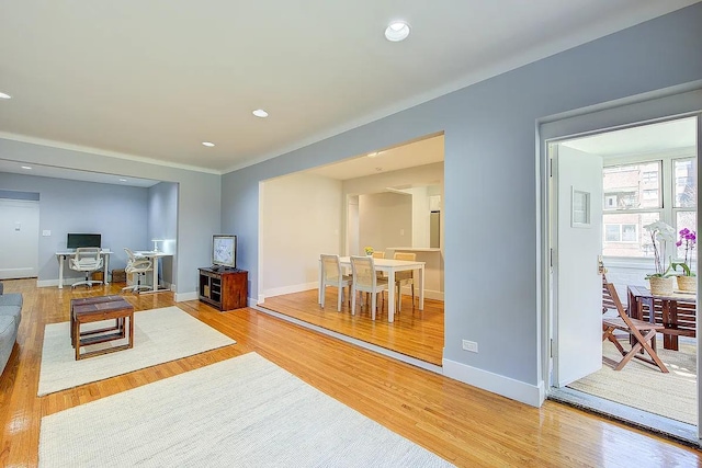 living area with baseboards, light wood finished floors, and recessed lighting