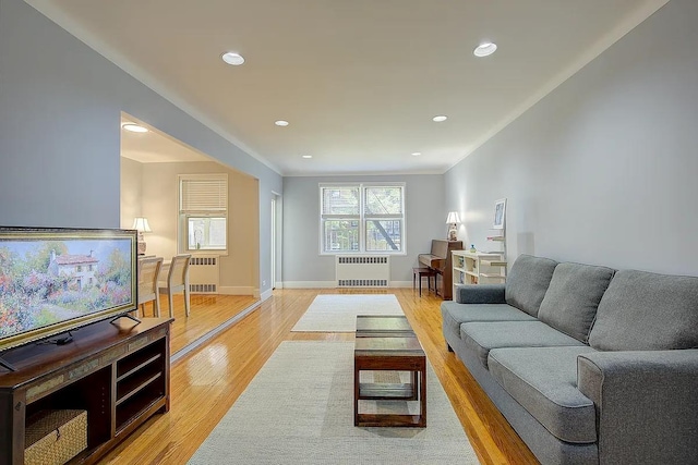 living room with recessed lighting, radiator heating unit, and light wood-type flooring