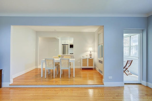 dining area with light wood-style floors and baseboards