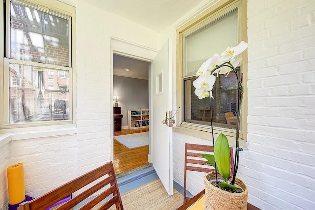interior space with brick wall and wood finished floors