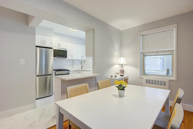 dining space featuring radiator heating unit, marble finish floor, and baseboards