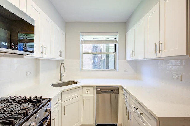kitchen featuring tasteful backsplash, a sink, stainless steel appliances, light countertops, and white cabinets