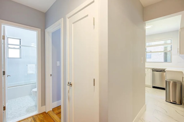 hallway with baseboards and a wealth of natural light