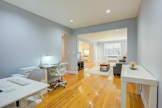 office space with baseboards, radiator heating unit, light wood-style floors, and recessed lighting