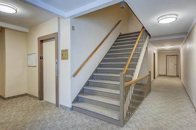 stairs featuring baseboards, elevator, and carpet
