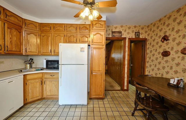 kitchen featuring white appliances, a sink, ceiling fan, and light tile patterned flooring