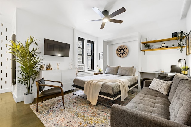 bedroom featuring baseboards, a ceiling fan, and wood finished floors