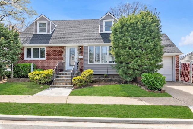 cape cod-style house featuring a front lawn, a garage, a shingled roof, brick siding, and concrete driveway