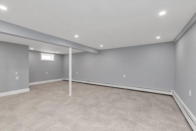 basement with recessed lighting, a baseboard heating unit, and baseboards