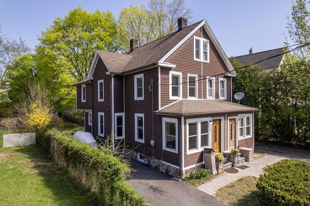 back of property with fence, a shingled roof, entry steps, and a chimney