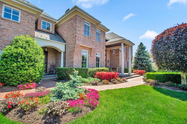 27 True Harbour Way W, Islip, NY 11795 - view of front facade featuring covered porch, a front lawn, and brick siding