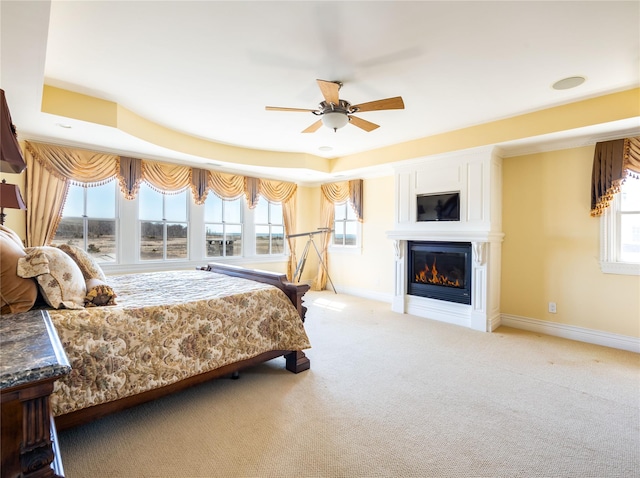 27 True Harbour Way W, Islip, NY 11795 - bedroom featuring baseboards, a glass covered fireplace, light carpet, and ceiling fan