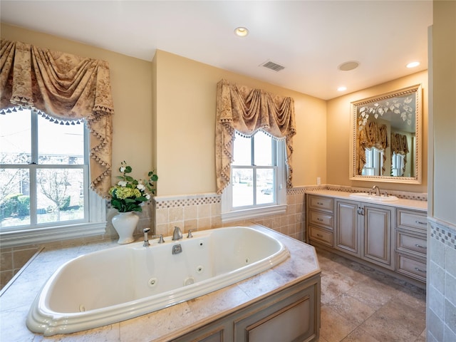 27 True Harbour Way W, Islip, NY 11795 - bathroom with a tub with jets, vanity, tile walls, and recessed lighting