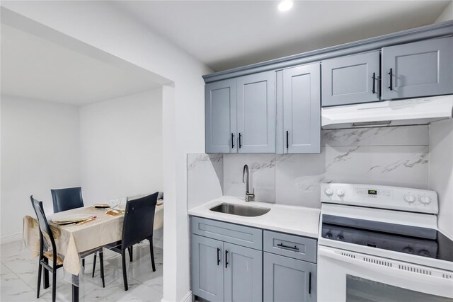 324 Ralph Ave, Brooklyn, NY 11233 - kitchen featuring electric range, light marble finish flooring, under cabinet range hood, gray cabinetry, and recessed lighting