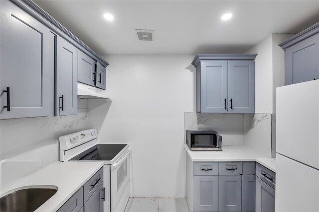 324 Ralph Ave, Brooklyn, NY 11233 - kitchen featuring white appliances, light marble finish flooring, light countertops, decorative backsplash, and recessed lighting