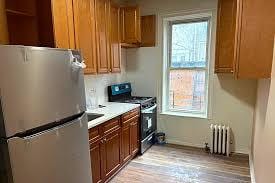 kitchen with freestanding refrigerator, radiator, range with gas stovetop, and a healthy amount of sunlight