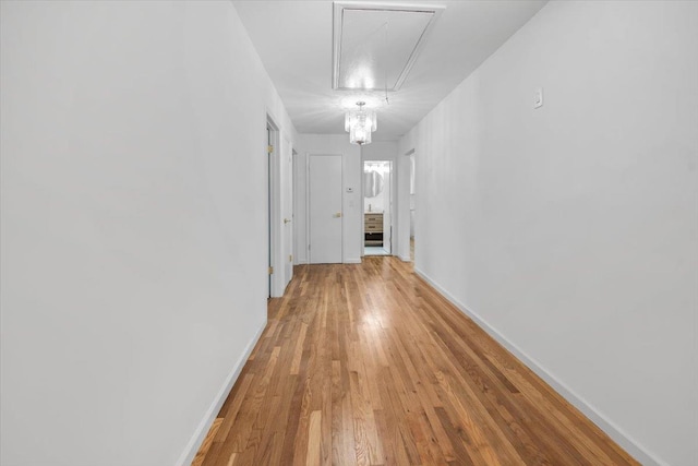 10 Mohawk Rd, Yonkers, NY 10710 - corridor featuring attic access, baseboards, a notable chandelier, and light wood-style flooring