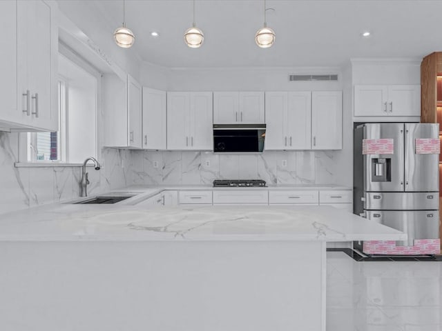 kitchen with a sink, gas cooktop, light stone countertops, and stainless steel refrigerator with ice dispenser