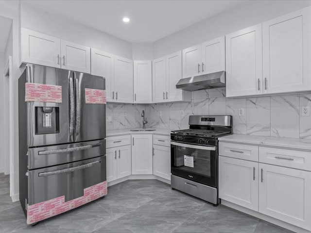 kitchen featuring under cabinet range hood, white cabinetry, appliances with stainless steel finishes, and a sink