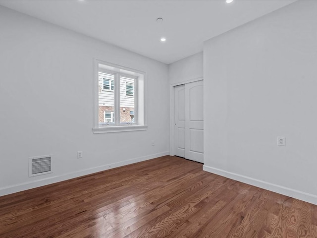 unfurnished bedroom featuring visible vents, recessed lighting, baseboards, and wood finished floors