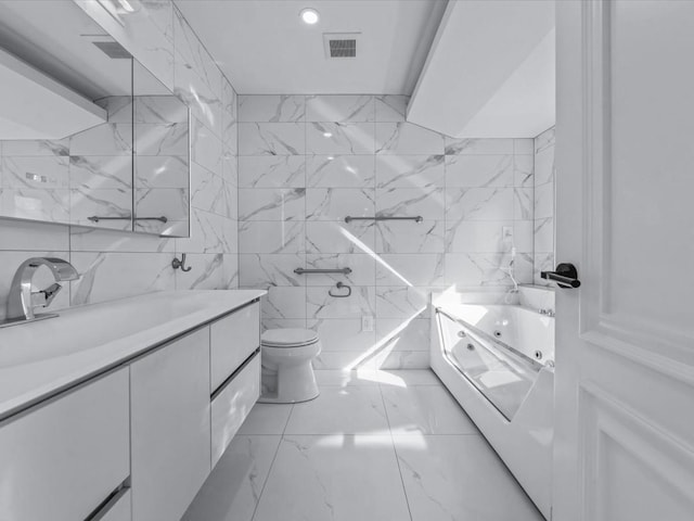 bathroom with vanity, toilet, marble finish floor, tile walls, and visible vents