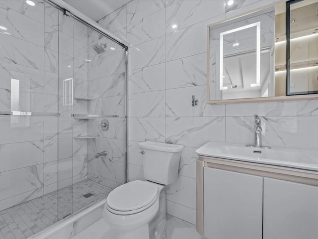 full bathroom with vanity, a stall shower, toilet, and tile walls