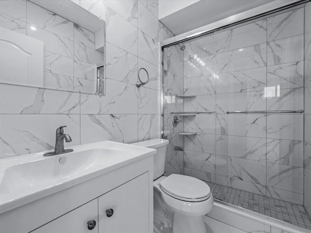 bathroom featuring vanity, toilet, tile walls, and a stall shower