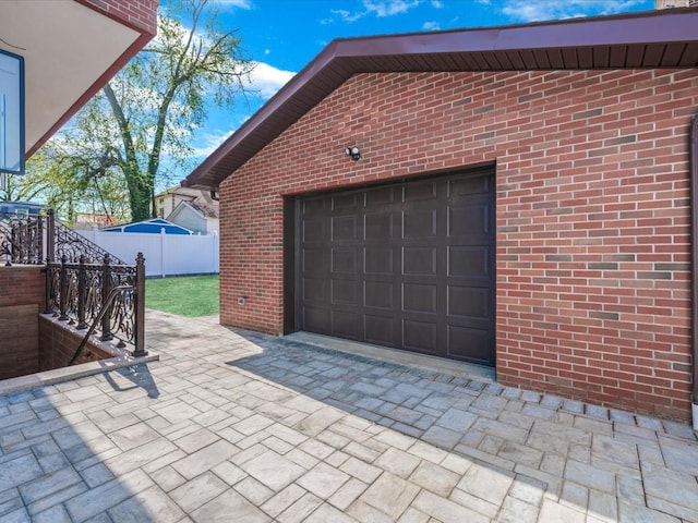 garage featuring fence and driveway