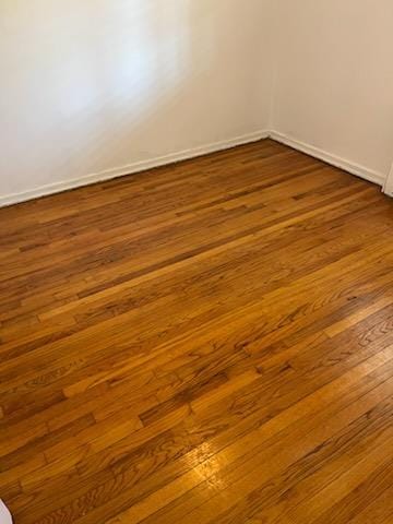 unfurnished room featuring baseboards and dark wood finished floors