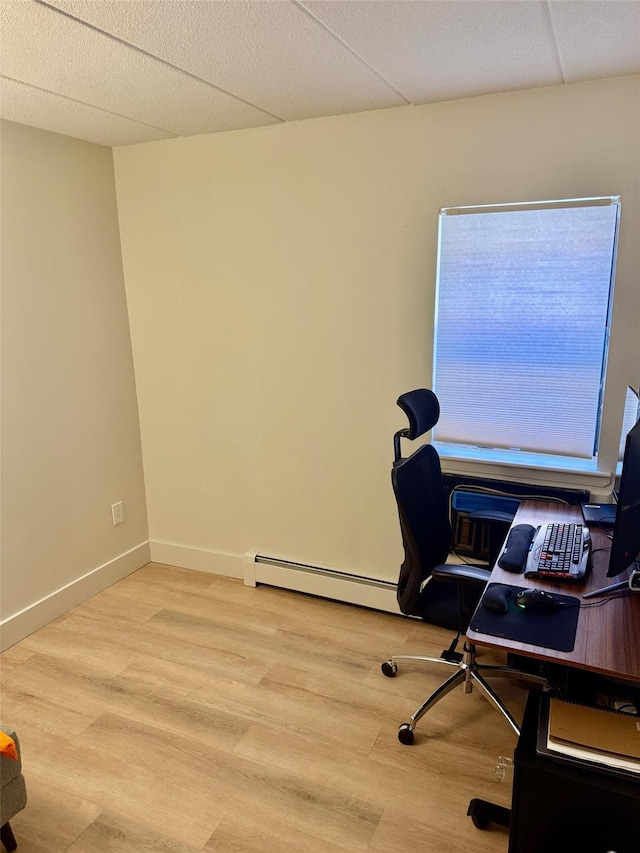 office area with a baseboard radiator, light wood-style floors, and baseboards